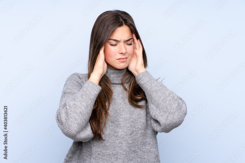 Teenager Brazilian girl over isolated blue background with headache Teenager Brazilian girl over isolated blue background with headache