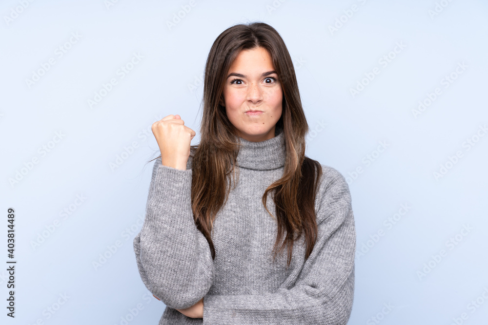 Teenager Brazilian girl over isolated blue background with angry gesture Teenager Brazilian girl over isolated blue background with angry gesture