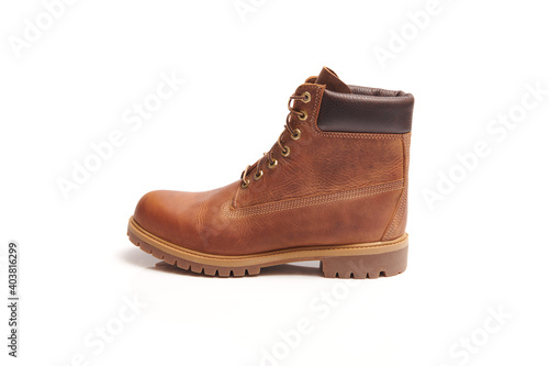 Mens leather brown waterproof boots for winter or autumn hiking isolated on white background. Mens fashion, trendy footwear. Close up view.