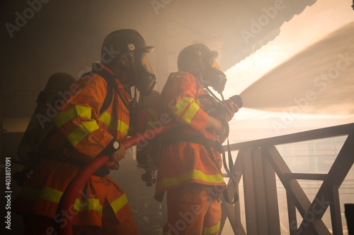 Firefighters spraying water on fire