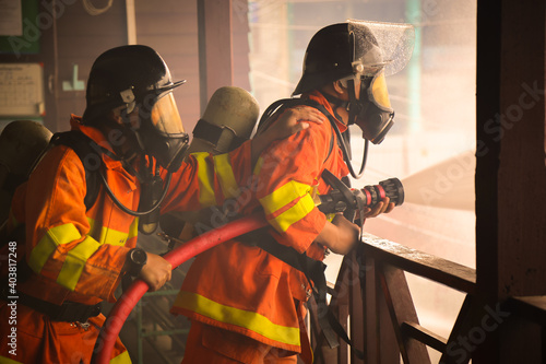 Firefighters spraying water on fire