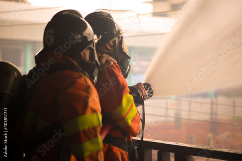 Firefighters spraying water on fire