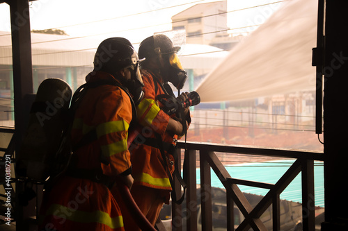 Firefighters spraying water on fire