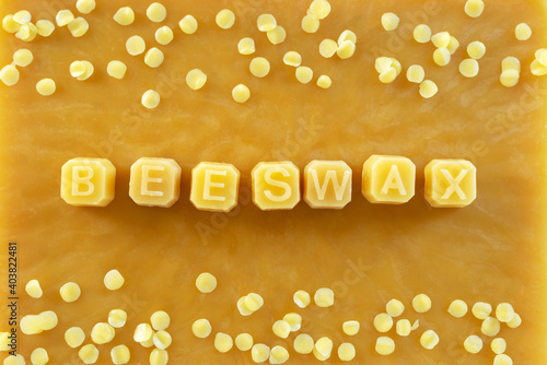 beeswax letters made from yellow natural beeswax on  beeswax texture background. photo