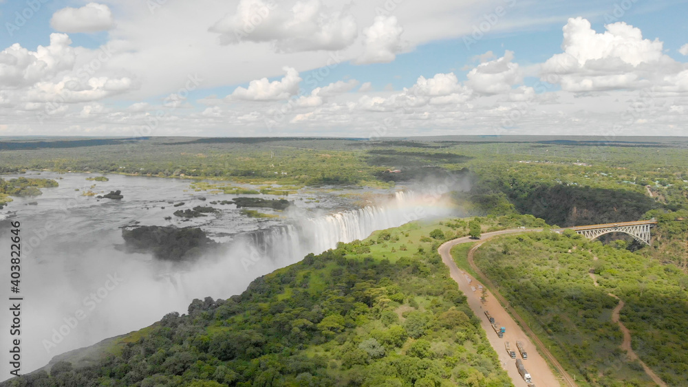 Die Viktoriafälle in Sambia und Simbabwe mit dem Sambesi Fluss und einem Regenbogen, aufgenommen aus einem Helikopter