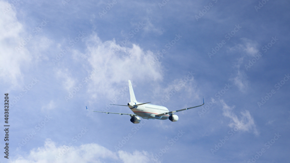 Zoom photo of passenger airplane taking off in cloudy deep blue sky