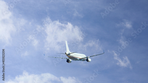 Zoom photo of passenger airplane taking off in cloudy deep blue sky
