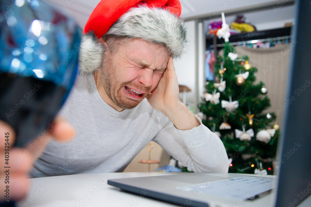 Young happy man having video call via laptop with wine, celebrating Christmas alone at home Young happy man having video call via laptop with wine, celebrating Christmas alone at home