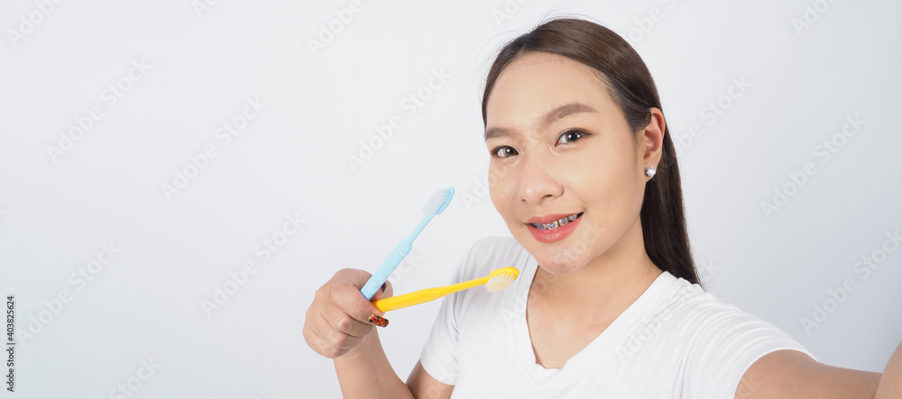 Braces teeth. Dental brace sexy girl smile holding toothbrush and looking to camera. white teeth with blue braces. Dental care. Asian woman with contact lens and orthodontic. Dental care concept. Braces teeth. Dental brace sexy girl smile holding toothbrush and looking to camera. white teeth with blue braces. Dental care. Asian woman with contact lens and orthodontic. Dental care concept.