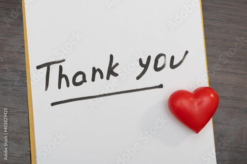 Schedule notepad on dark table with thank you inscription and red heart