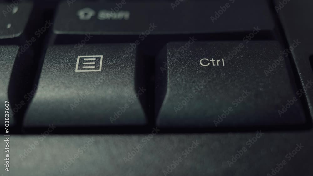 Person finger repeatedly pressing the ctrl key on a black office keyboard. Macro shot. Person finger repeatedly pressing the ctrl key on a black office keyboard. Macro shot.