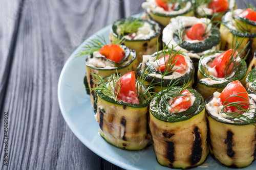 Zucchini rolls with cream cheese , tomatoes and dill