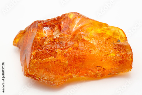 A piece of unique transparent yellow amber on a white background. A semi-precious stone made from petrified resin. Material for jewelry and ornaments. Copal. Sun stone. Fossil resin. Baltic gem.