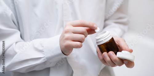 the medicine pill is placed in the jar by the child's hands
