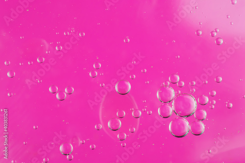 oil drops on water on a pink background