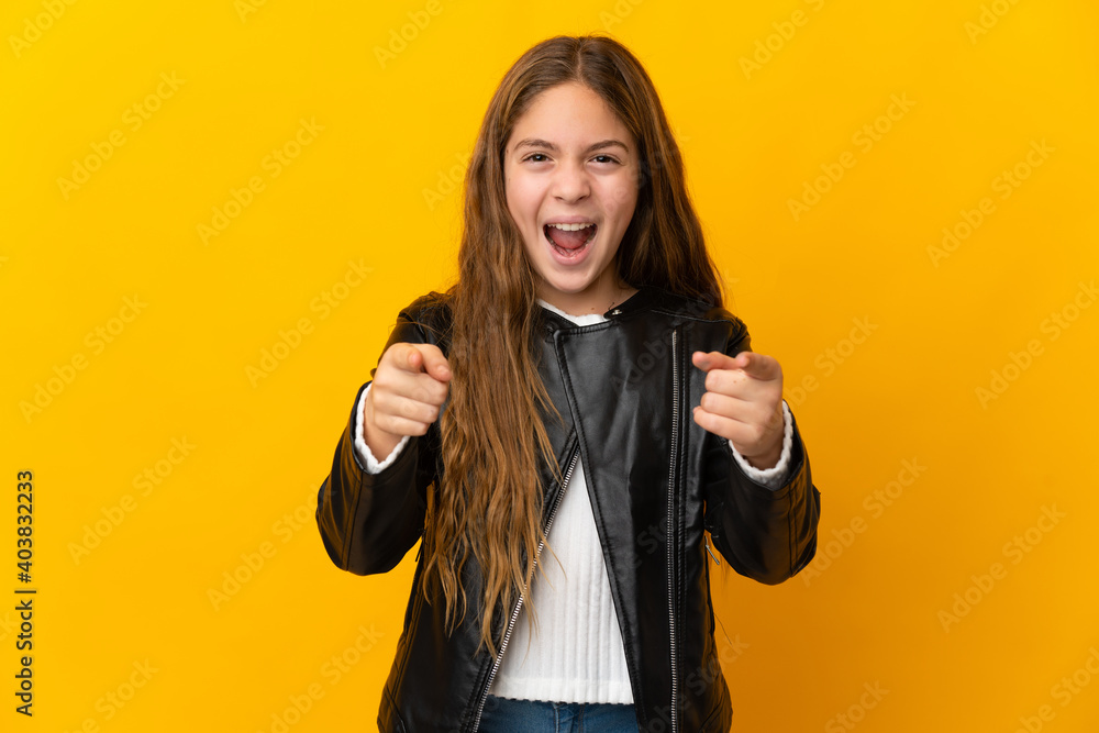 Child over isolated yellow background surprised and pointing front Child over isolated yellow background surprised and pointing front