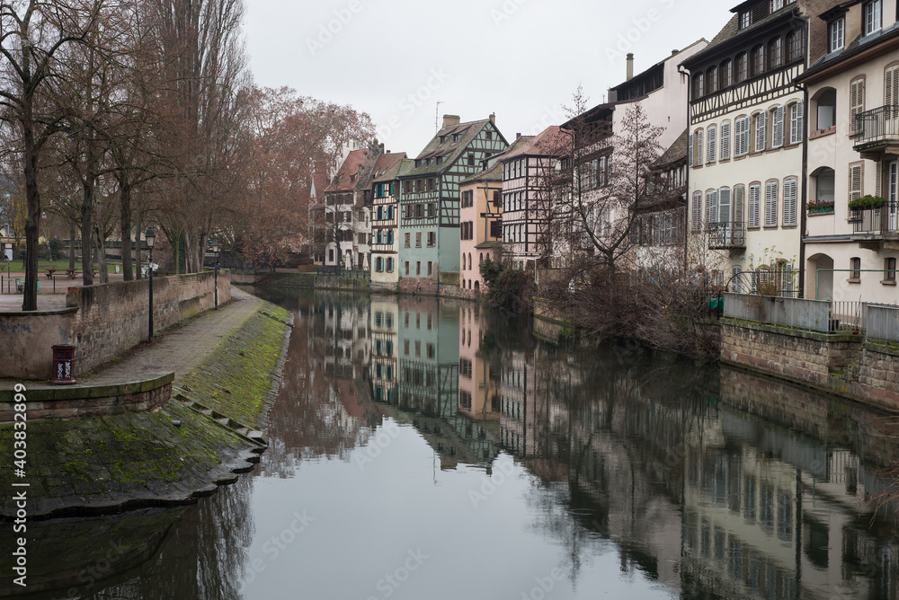 view of medieval buildings reflection on the channel at little france quarter in Strasbourg by winter