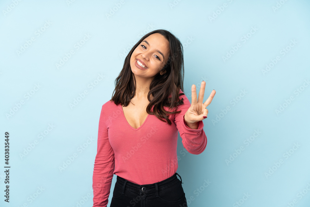 Young mixed race woman isolated on blue background happy and counting three with fingers Young mixed race woman isolated on blue background happy and counting three with fingers