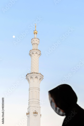 Silhouette of muslim woman, covered in black abaya in Grand mosque photo