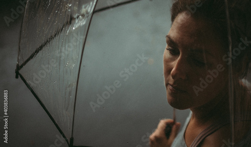 Close up of a woman holding an umbrella on a rainy day.