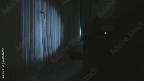 Full length of robber. Man with flashlight and bag in living room. photo