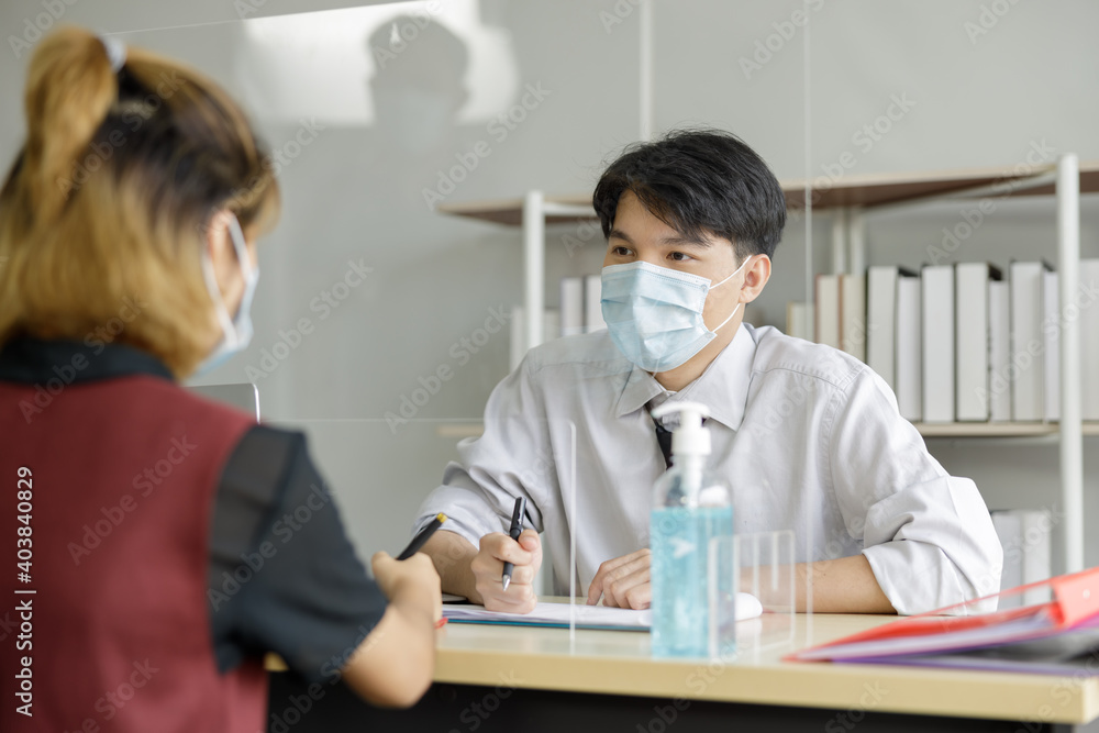 Safe communication at work and social distance during covid-19 quarantine. Colleagues talk through protective glass, Safe communication at work and social distance during covid-19 quarantine. Colleagues talk through protective glass,