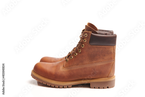 Pair of Mens leather brown waterproof boots for winter or autumn hiking isolated on white background. Mens fashion, trendy footwear. Close up view.
