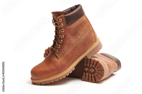 Pair of Mens leather brown waterproof boots for winter or autumn hiking isolated on white background. Mens fashion, trendy footwear. Close up view. photo