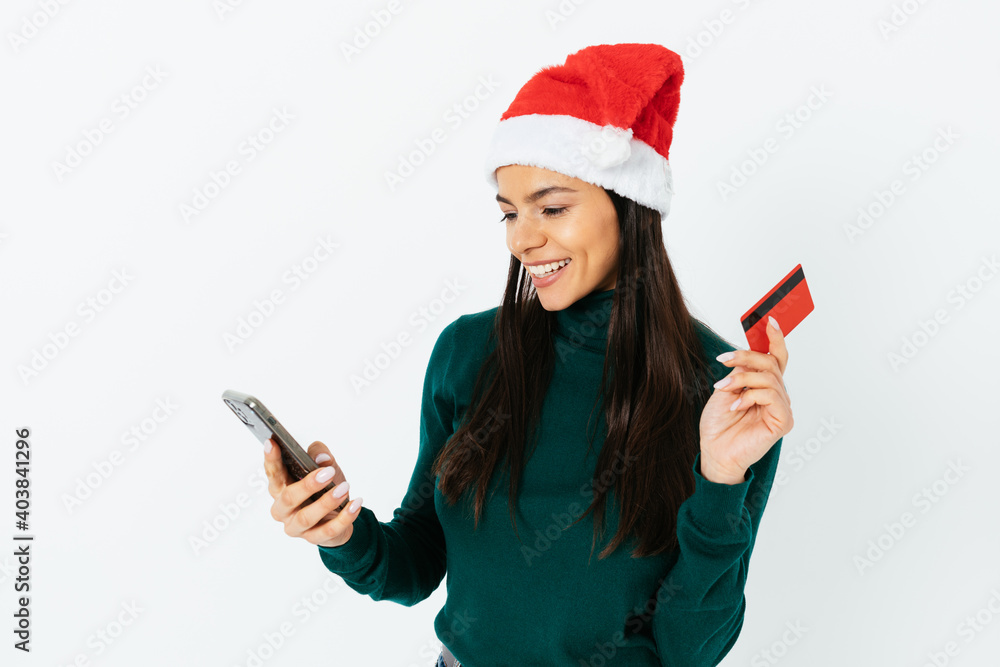 Young woman in santa hat with bank card and mobile phone Young woman in santa hat with bank card and mobile phone