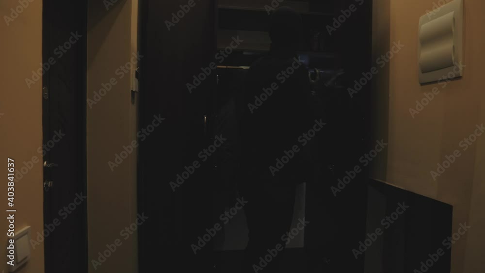 Full length of robber. Man with flashlight and bag in living room. Full length of robber. Man with flashlight and bag in living room.