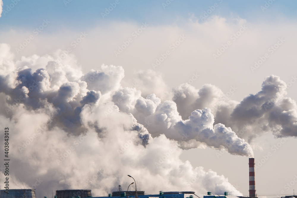 industrial chimneys with heavy smoke causing air pollution on the blue sky background industrial chimneys with heavy smoke causing air pollution on the blue sky background