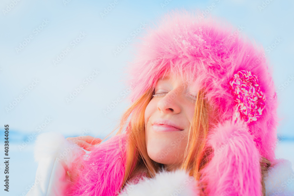 Pretty girl with pink hat and white lashes enjoying the winter sun