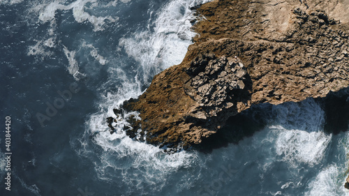 ocean waves hit the rock, topshot aerial view in Portugal