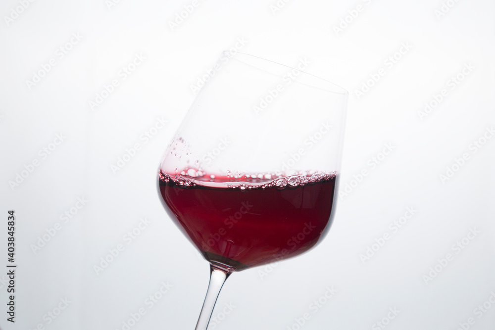 Red wine in a glass on a white background. Red wine in a glass on a white background.