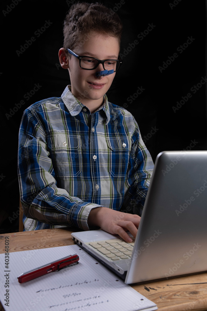 Boy typing on computer at home for school Boy typing on computer at home for school