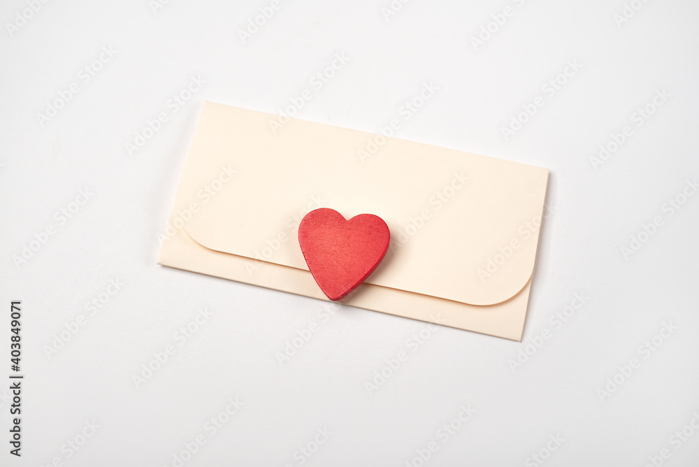 Envelope and red heart on the light (white) background. Flat lay, top view, space for text. Romantic love letter for Valentine's day concept. Envelope and red heart on the light (white) background. Flat lay, top view, space for text. Romantic love letter for Valentine's day concept.