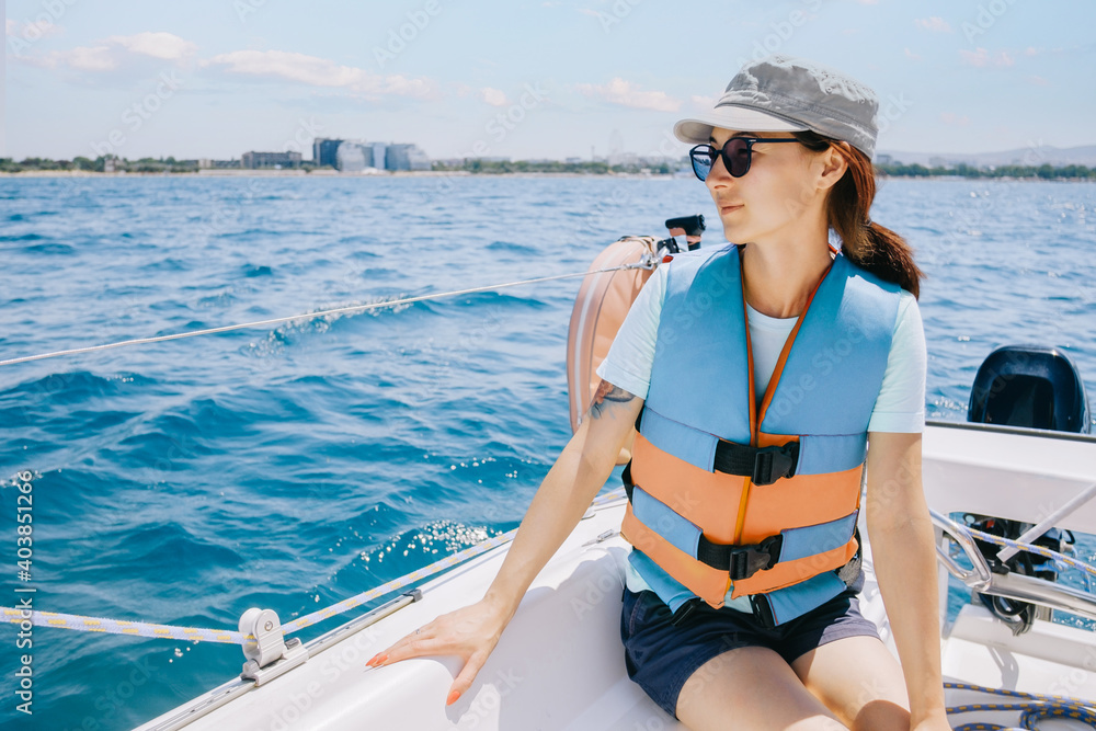 Portrait of a young woman on a yacht. Weekend sailing trip.