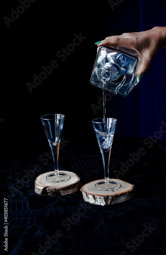 Woman hand with a bottle pouring a drink into a cutted glass