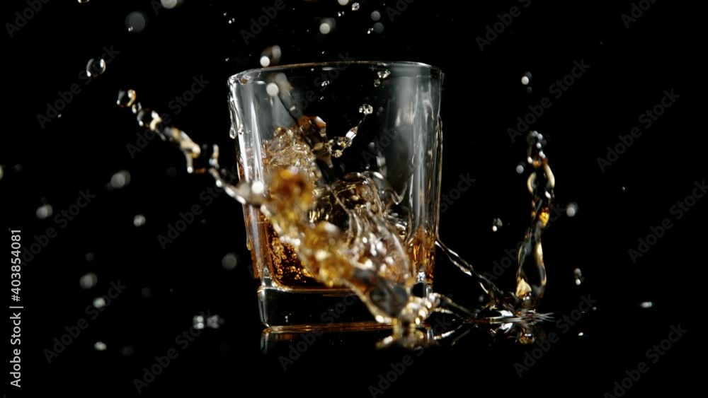 Super slow motion of falling ice cube into whiskey drink. Filmed on high speed cinema camera, 1000 fps. Super slow motion of falling ice cube into whiskey drink. Filmed on high speed cinema camera, 1000 fps.