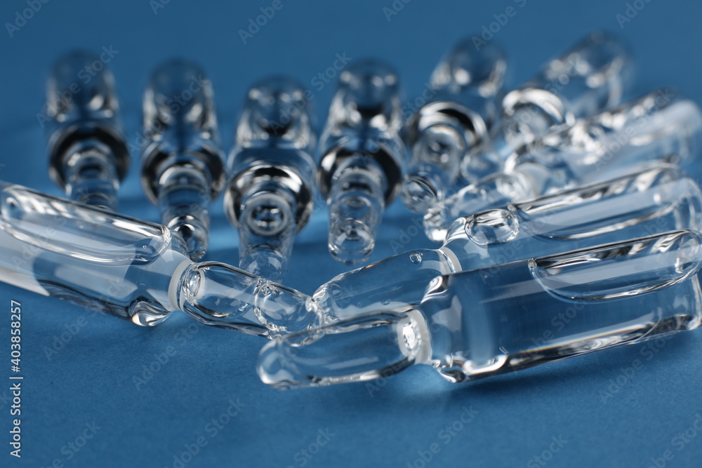 Glass vials with vaccine on blue background Glass vials with vaccine on blue background