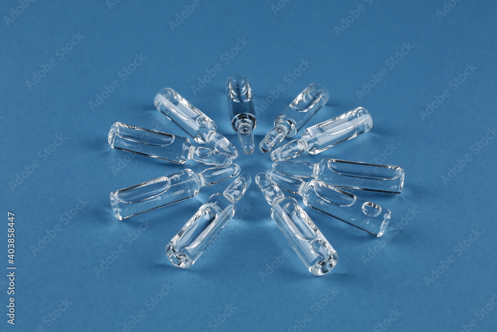 Glass vials with vaccine on blue background Glass vials with vaccine on blue background