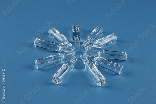Glass vials with vaccine on blue background