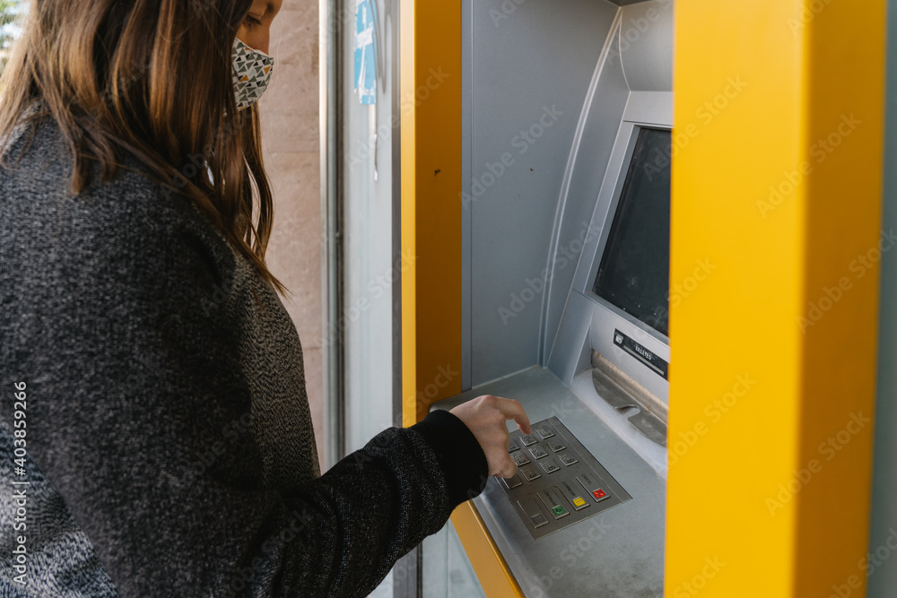 woman withdrawing money from an ATM woman withdrawing money from an ATM