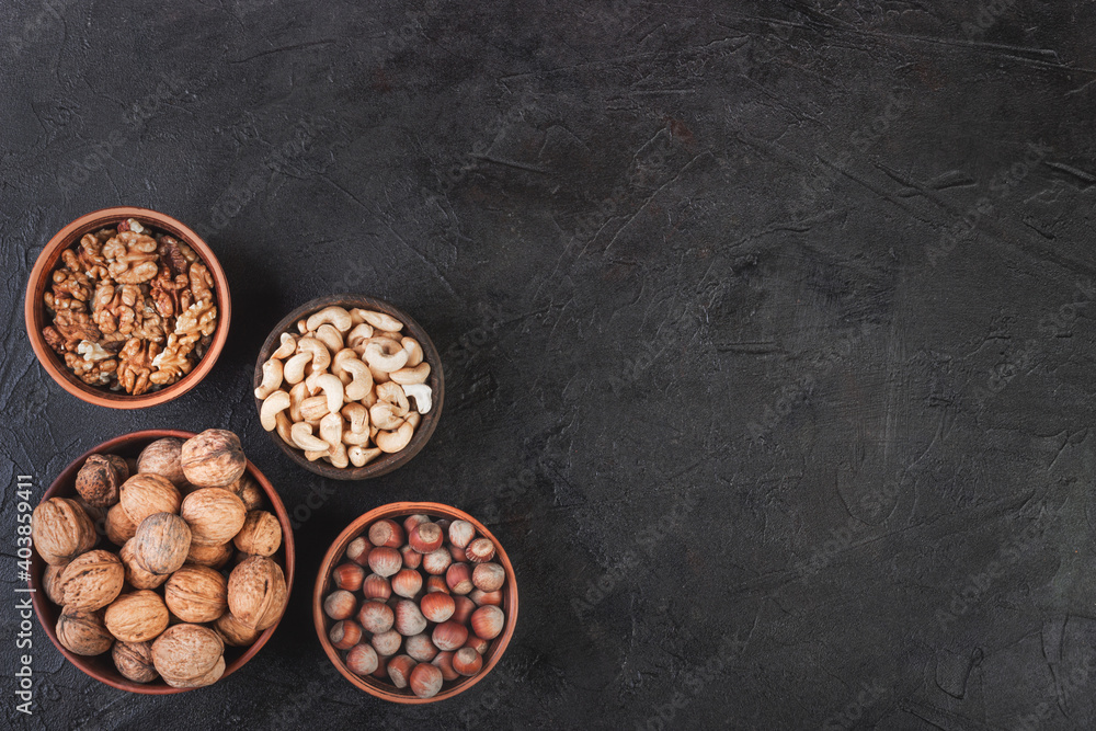 Different nuts in dishes, walnuts, hazelnuts, cashews and almonds