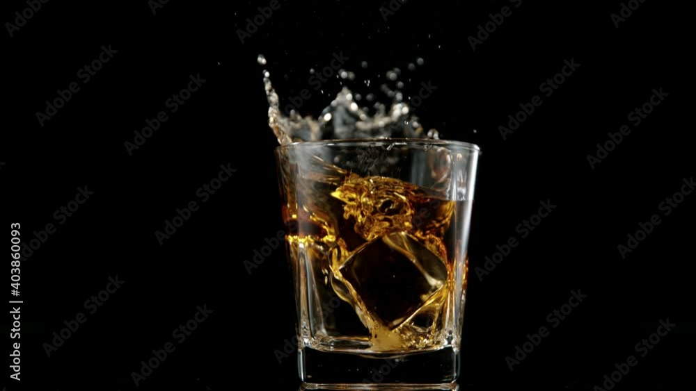 Super slow motion of falling ice cube into whiskey drink. Filmed on high speed cinema camera, 1000 fps. Super slow motion of falling ice cube into whiskey drink. Filmed on high speed cinema camera, 1000 fps.