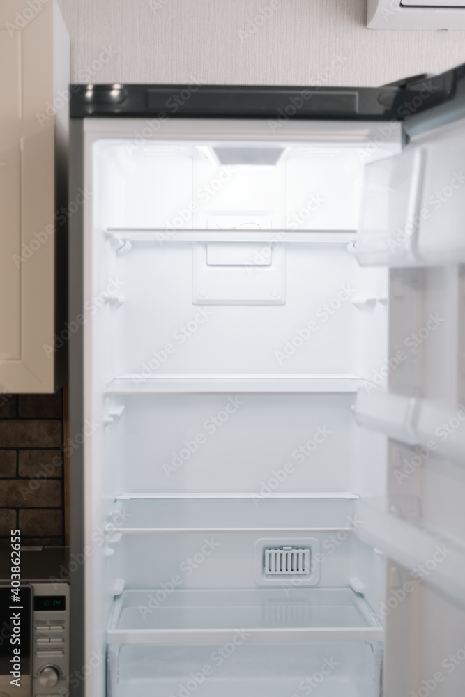 Empty open white refrigerator in the kitchen. Empty open white refrigerator in the kitchen.