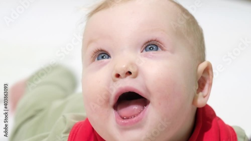 Adorable baby girl is playing and looking at the camera, white backgrond

