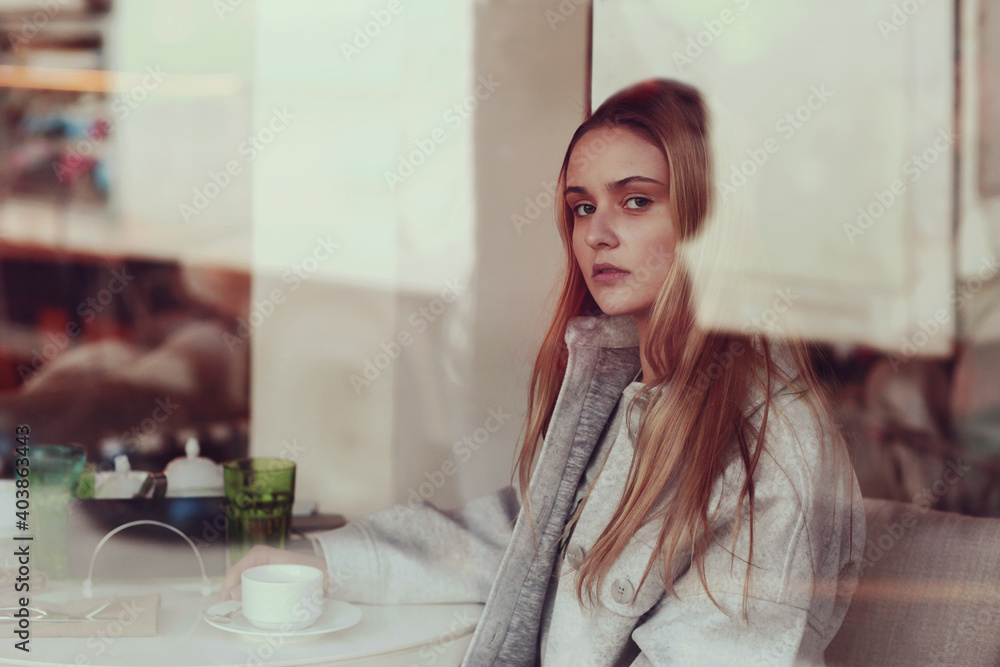 blond long hair girl close up portrait through the cafe window blond long hair girl close up portrait through the cafe window