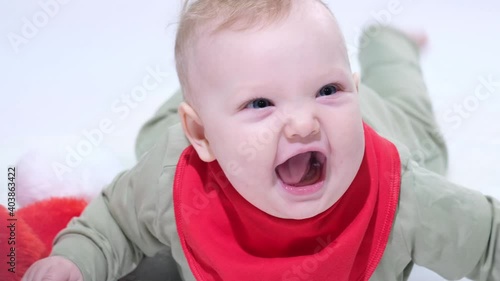 Adorable baby girl is playing and looking at the camera, white backgrond
