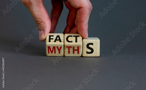 Facts or myths symbol. Businessman hand turns cubes and changes the word 'myths' to 'facts'. Beautiful grey background, copy space. Business and facts or myths concept.